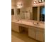 Bathroom with dual sinks, white cabinets and large mirror at 30049 Emmetts Ct, Wesley Chapel, FL 33543