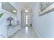 Inviting entryway featuring a glass-topped console table, stylish mirror, and decorative light fixture at 31452 Cabana Rye Ave, San Antonio, FL 33576