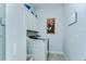 Laundry room with front load washer and dryer, upper cabinets, and decorated with floral art at 31452 Cabana Rye Ave, San Antonio, FL 33576