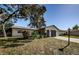 Exterior view of home with lawn, mature trees, and an attached garage at 3151 Lecanto St, Holiday, FL 34691