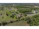 Wide aerial perspective of the property, highlighting its generous lot, nearby pond, and mature landscaping at 34201 Kentucky Derby Pl, Dade City, FL 33525