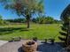 Manicured backyard featuring a brick fire pit and beautiful green space at 34201 Kentucky Derby Pl, Dade City, FL 33525