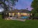 Landscaped backyard with a screened pool area and cozy fire pit seating at 34201 Kentucky Derby Pl, Dade City, FL 33525