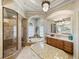 Bathroom featuring a glass-enclosed shower, soaking tub, and dual vanities with marble countertops at 34201 Kentucky Derby Pl, Dade City, FL 33525