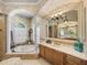 Elegant bathroom with a soaking tub, columns, and a large mirror reflecting the shower area at 34201 Kentucky Derby Pl, Dade City, FL 33525