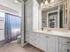Spacious bathroom featuring white cabinets and a large framed mirror at 34201 Kentucky Derby Pl, Dade City, FL 33525