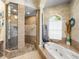 Bathroom featuring a glass-enclosed shower, soaking tub, and decorative items at 34201 Kentucky Derby Pl, Dade City, FL 33525