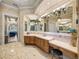 Luxurious bathroom featuring marble counters, a large mirror, and decorative lighting at 34201 Kentucky Derby Pl, Dade City, FL 33525