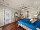 Primary bedroom featuring a king bed, wooden floors, and door to the outside at 34201 Kentucky Derby Pl, Dade City, FL 33525