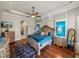 Bedroom with a king bed, wooden floors, and custom built-in shelving with decorative lighting at 34201 Kentucky Derby Pl, Dade City, FL 33525