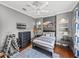 Well-lit bedroom featuring hardwood floors, gray walls, and a blue decorative rug at 34201 Kentucky Derby Pl, Dade City, FL 33525