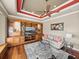 Well-lit den with hardwood floors, built-in shelves and cabinets, and a ceiling fan at 34201 Kentucky Derby Pl, Dade City, FL 33525
