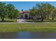 Inviting home exterior with expansive lawn, mature trees, and a tranquil waterfront view at 34201 Kentucky Derby Pl, Dade City, FL 33525