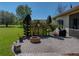 Outdoor fire pit and sitting area nestled next to the home's landscaped backyard at 34201 Kentucky Derby Pl, Dade City, FL 33525