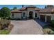 Close-up of house showcasing brick driveway, landscaped yard, and neutral color palette at 34201 Kentucky Derby Pl, Dade City, FL 33525