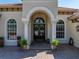 Elegant front entrance with detailed architectural features, potted plants, and stone walkway at 34201 Kentucky Derby Pl, Dade City, FL 33525