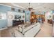 Bright living room with a TV, ceiling fan, and kitchen area at 34201 Kentucky Derby Pl, Dade City, FL 33525