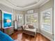Comfortable seating area in the main bedroom, featuring hardwood floors and shutters overlooking the property at 34201 Kentucky Derby Pl, Dade City, FL 33525
