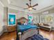 Luxurious main bedroom with stylish decor, tray ceiling, plantation shutters, and hardwood floors at 34201 Kentucky Derby Pl, Dade City, FL 33525