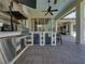 Outdoor kitchen with stainless steel appliances, stone backsplash and bar seating at 34201 Kentucky Derby Pl, Dade City, FL 33525