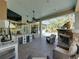 View of outdoor space with fireplace, kitchen with bar, in-ground pool and seating at 34201 Kentucky Derby Pl, Dade City, FL 33525