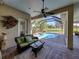 Covered patio with comfortable seating and outdoor views of the in-ground pool at 34201 Kentucky Derby Pl, Dade City, FL 33525