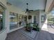 Charming covered patio featuring a cozy seating area and view of the screened-in pool at 34201 Kentucky Derby Pl, Dade City, FL 33525