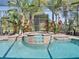 Close up of the enclosed spa, with lush tropical landscaping and a view into the backyard at 34201 Kentucky Derby Pl, Dade City, FL 33525