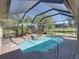 Enclosed pool area with a spa, surrounded by tropical landscaping, and a brick-paved patio and sunning area at 34201 Kentucky Derby Pl, Dade City, FL 33525