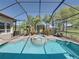 Spa with surrounding pool, enclosed by a screen, featuring lush tropical landscaping and views of the backyard at 34201 Kentucky Derby Pl, Dade City, FL 33525