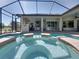 Beautiful in-ground pool and spa featuring a screened enclosure and covered outdoor area at 34201 Kentucky Derby Pl, Dade City, FL 33525