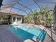 Enclosed pool with a spa, lush landscaping, brick-paved deck, and a screened enclosure with views of the property at 34201 Kentucky Derby Pl, Dade City, FL 33525