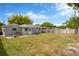View of the backyard showing lawn, the back of the house with light neutral paint and a privacy fence at 5261 43Rd N Ave, St Petersburg, FL 33709