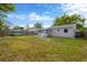 Shot of the backyard with grass, and the back of the house painted with a light neutral color at 5261 43Rd N Ave, St Petersburg, FL 33709