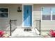 Home entryway features a stylish blue front door, black railings, manicured landscaping, and visible house number at 5261 43Rd N Ave, St Petersburg, FL 33709