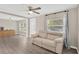 Open-concept living room with hardwood floors, neutral paint, ceiling fan, and natural light from large windows at 5261 43Rd N Ave, St Petersburg, FL 33709