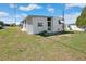 Back exterior of home with green lawn at 5306 Mary St, Zephyrhills, FL 33542