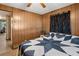 Bedroom featuring wood paneled walls and a bed with a star patterned quilt at 5306 Mary St, Zephyrhills, FL 33542