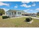 Inviting mobile home showcasing a lovely front yard and covered porch, perfect for relaxing in a quiet setting at 5306 Mary St, Zephyrhills, FL 33542