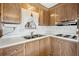 Compact kitchen area with double basin sink, white countertops, and ample wooden cabinet storage space at 5306 Mary St, Zephyrhills, FL 33542