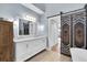 This bathroom features a double vanity, wood floors, and barn door access to water closet at 553 Haven Point Dr, Treasure Island, FL 33706