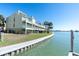 Waterfront condo with balconies, lawn, and palms under a sunny sky at 553 Haven Point Dr, Treasure Island, FL 33706