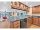 Spacious kitchen featuring wood cabinets, stainless steel dishwasher, and a view of the waterfront living room at 553 Haven Point Dr, Treasure Island, FL 33706
