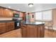 Well-lit kitchen with stainless steel appliances, dark countertops, a center island, and wood flooring at 553 Haven Point Dr, Treasure Island, FL 33706