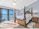 Waterfront main bedroom featuring a wooden four-poster bed, balcony access and serene water views at 553 Haven Point Dr, Treasure Island, FL 33706