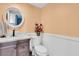 Cozy powder room with marble countertop, decorative flowers, and wainscoting paneling at 553 Haven Point Dr, Treasure Island, FL 33706
