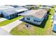 Aerial view of a well-maintained home with a long driveway and carport, surrounded by lush greenery at 5745 Pawnee St, Zephyrhills, FL 33542