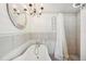 Elegant bathroom featuring a freestanding tub, stylish chandelier, and separate shower area at 5745 Pawnee St, Zephyrhills, FL 33542