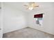 Bright bedroom with white walls, neutral carpet, window, and a ceiling fan at 5745 Pawnee St, Zephyrhills, FL 33542