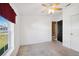 Bright bedroom with white walls, neutral carpet, a window and black door at 5745 Pawnee St, Zephyrhills, FL 33542